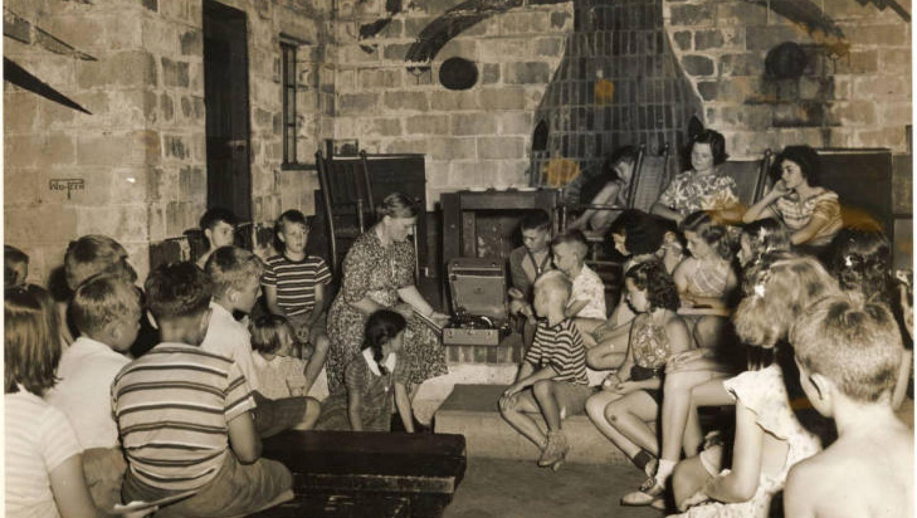 学生们坐在马萨索伊特营地的一栋建筑里听音乐. 